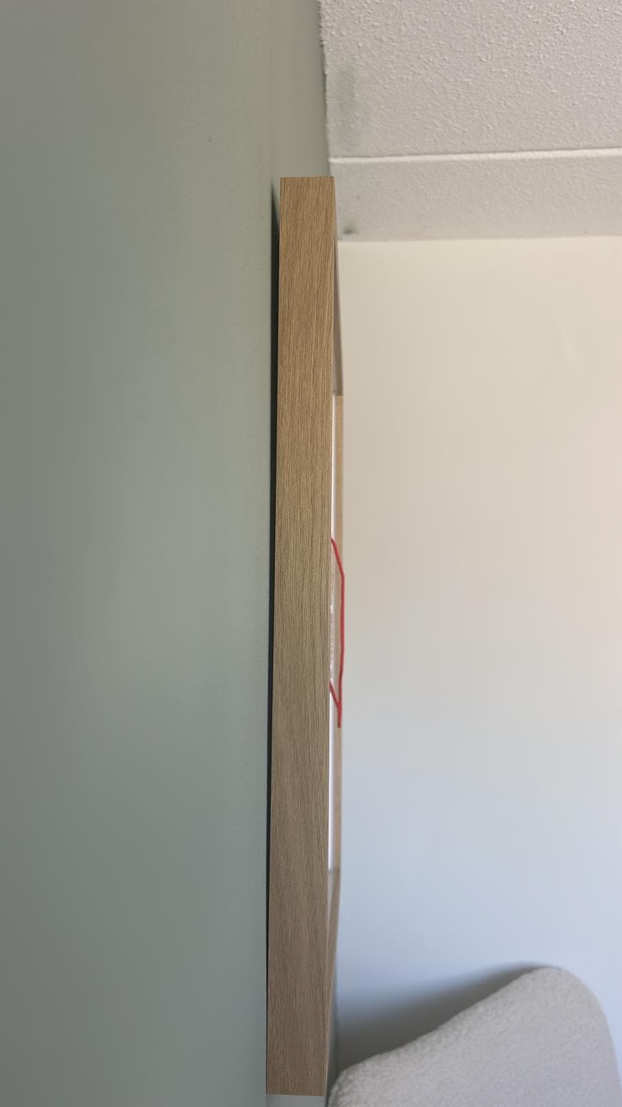The edge profile of the solid oak frame, close up, showing the grain and the glass.
